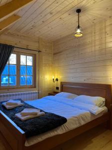1 dormitorio con 1 cama con 2 toallas en Planinska kuca Grujic, en Kolašin