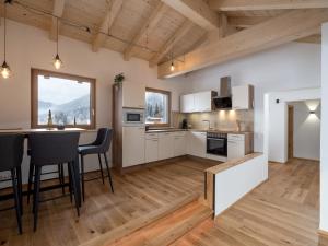 a kitchen with white cabinets and a table with chairs at Appartement Waldruhe in Söll