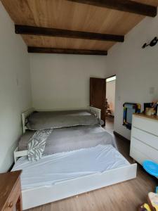 1 dormitorio con 1 cama grande y techo de madera en Calma Nativa, en Maldonado