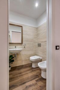 uma casa de banho com um lavatório, um WC e um espelho. em BOUTIQUE FLAT -colosseo- em Roma