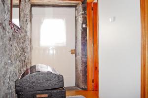 Cette chambre dispose d'une porte avec une chaise et une fenêtre. dans l'établissement holiday home, Praínha de Baixo, Pico, Azores, à Prainha de Baixo