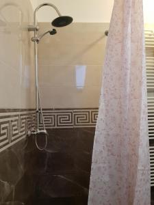 y baño con ducha con cortina blanca. en Hotel Restaurant La Passione, en Tecuci