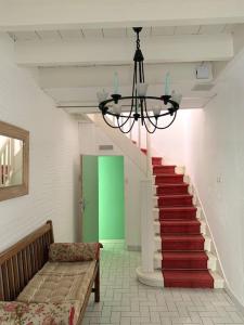 un pasillo con una escalera con un banco y una puerta verde en Maison de ville confortable avec piscine, en Pons