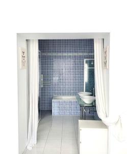 Baño blanco con bañera y lavamanos en Maison de ville confortable avec piscine, en Pons