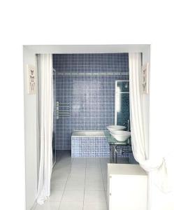 a white bathroom with a tub and a sink at Maison de ville confortable avec piscine in Pons