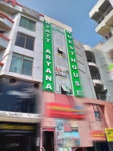 a building with a green sign on the side of it at HYATT ARYANA Guesthouse 1 in Islamabad