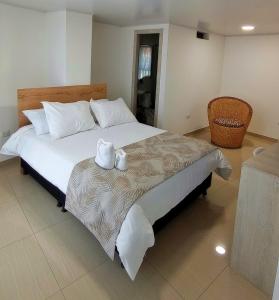 a bedroom with a bed with two towels on a table at Hotel Meraki Popayán in Popayan