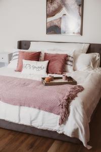 a bed with pink and white sheets and pillows at The Free Spirit Retreat in Newaygo