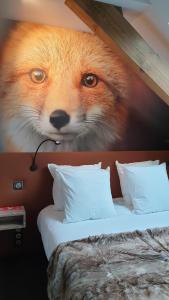 a painting of a fox on a wall next to a bed at Les Loges Du Parc in Gérardmer