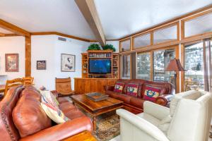 a living room with leather furniture and a tv at Powder Run B-21 in Park City