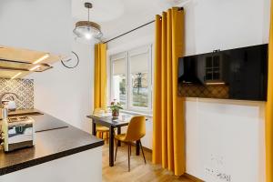 a kitchen with yellow curtains and a table in a kitchen at Na zielonym Widoku in Wrocław +21 photos
