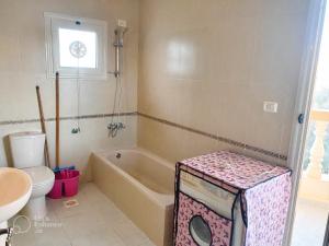 La salle de bains est pourvue d'une baignoire, de toilettes et d'un lavabo. dans l'établissement lucky house Dahab, à Dahab