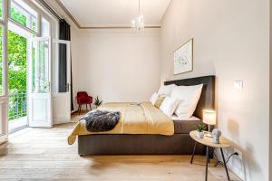a bedroom with a king sized bed and a table at Kaizl Park Residence in Prague