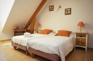 two twin beds in a room with an attic at Chambre D'hôtes Francine et Gérard in Le Mans