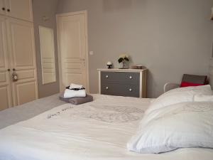 ルマンにあるChambre D'hôtes Francine et Gérardのベッドルーム(大きな白いベッド、ドレッサー付)