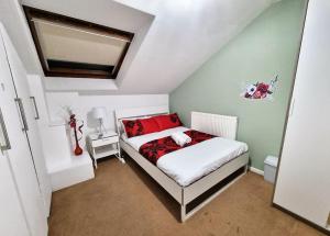 um quarto com uma cama com almofadas vermelhas em *F1*5GH* Setup for your most relaxed & amazing stay + Free Parking + Free Fast WiFi * em Leeds