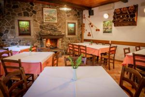 un restaurant avec des tables, des chaises et une cheminée dans l'établissement Tourist Farm Škerlj, à Dutovlje