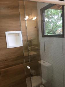 y baño con ducha y puerta de cristal. en Estância Liberdade, en Santo Antônio do Pinhal
