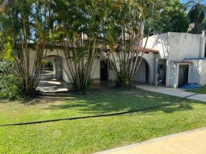 una casa con palmeras frente a un patio en Amplia casa Paso de la Patria en Paso de la Patria