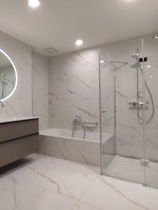 a white bathroom with a tub and a shower at Hotel Herzog Georg in Bad Liebenstein