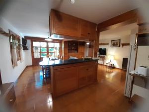 a large kitchen with wooden cabinets and a kitchen island at Casa de Huéspedes Silvana in San Martín de los Andes