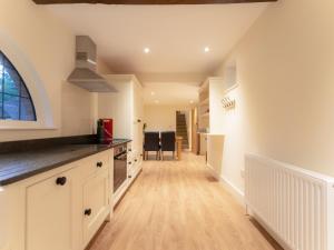 a kitchen with white cabinets and a counter top at The Turret in Wisley