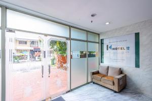 - un hall avec un canapé en face d'une porte en verre dans l'établissement K Hotel 12, à Singapour