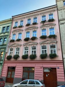 a pink building with windows and plants on it at Aparthotel City 5 in Prague