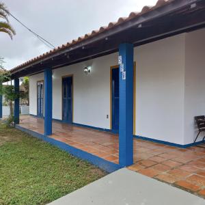 Casa de Praia na Praia dos Ingleses في فلوريانوبوليس: الهاوس كيبنج منزل فيه اعمده زرقاء