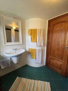 a bathroom with a sink and a mirror and towels at Quinta Perpetua, Casa Corvo in Alto do Sul