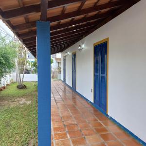 une terrasse couverte d'une maison avec portes bleues dans l'établissement Casa de Praia na Praia dos Ingleses, à Florianópolis