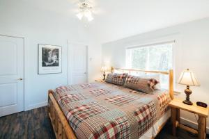 1 dormitorio con cama y ventana en Lakefront Stunning Home, only 30 min to Sugarloaf! en New Portland