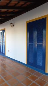 Habitación con puertas azules y suelo de baldosa. en Casa de Praia na Praia dos Ingleses, en Florianópolis