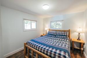 1 dormitorio con 1 cama y 2 ventanas en Lakefront Stunning Home, only 30 min to Sugarloaf! en New Portland