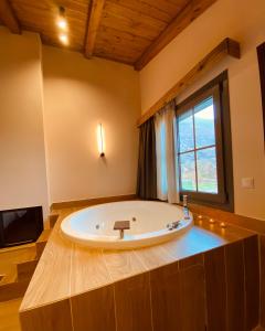 a large bath tub in a bathroom with a window at Irene's Resort in Kato Loutraki