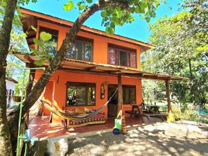 an orange house with a hammock in front of it at Casa Terra in Sámara