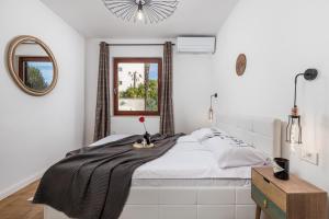 a white bedroom with a bed and a mirror at Apartment Mak in Opatija