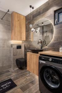 a bathroom with a sink and a washing machine at Apartment Mak in Opatija