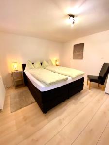 a bedroom with a large bed and a chair at Apartments Soldanella in Leukerbad