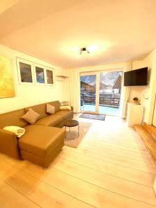 uma sala de estar com um sofá e uma televisão em Apartments Soldanella em Leukerbad