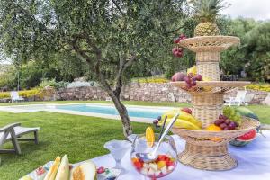 una mesa con cestas de fruta encima en Villa Janas Luxury Villa surrounded by large park, swimming pool, parking and Wifi en Alguer