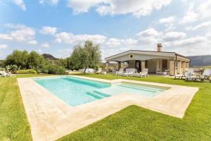 una piscina nel cortile di una casa di Villa Janas Luxury Villa surrounded by large park, swimming pool, parking and Wifi ad Alghero