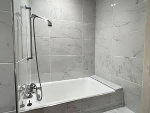 La salle de bains est pourvue d'une douche et d'une baignoire blanche. dans l'établissement Quartier piéton. T3 65m2. 2 chambres. 5 personnes., à Cauterets