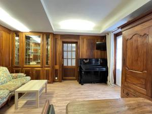 een woonkamer met een bank en een piano bij Quartier piéton. T3 65m2. 2 chambres. 5 personnes. in Cauterets