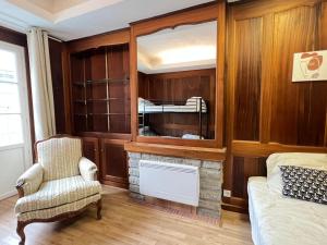 - une chambre avec une cheminée, un lit et une chaise dans l'établissement Quartier piéton. T3 65m2. 2 chambres. 5 personnes., à Cauterets 11 autres photos