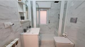 uma casa de banho branca com um WC e um chuveiro em Marifra Flats em Taormina