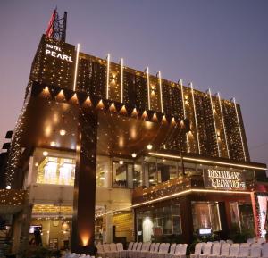 un gran edificio con luces de Navidad delante de él en Pearl Hotel & Banquets Ahmedabad, en Ahmedabad