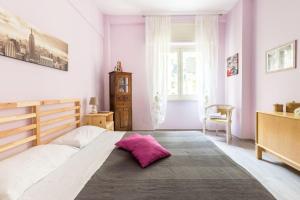 a bedroom with a large bed with a pink pillow on it at la casetta dei sogni in Rome