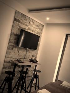 um quarto com uma mesa e uma televisão numa parede de tijolos em Nest studio Milmari Kopaonik em Kopaonik