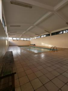 uma piscina vazia num edifício com piso em azulejo em Logement terrain de tennis/piscine 800m de la mer em Portimão